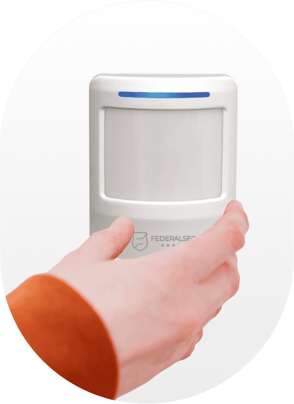 Mão instalando sensor de presença na parede